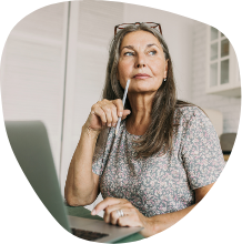 Woman sitting in front of a laptop and thinking